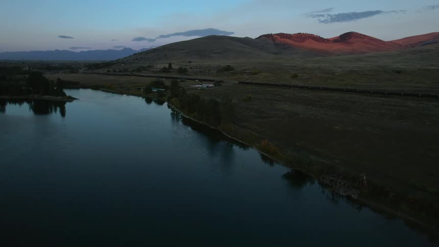 Aerial view of lake bank and hills at sunset