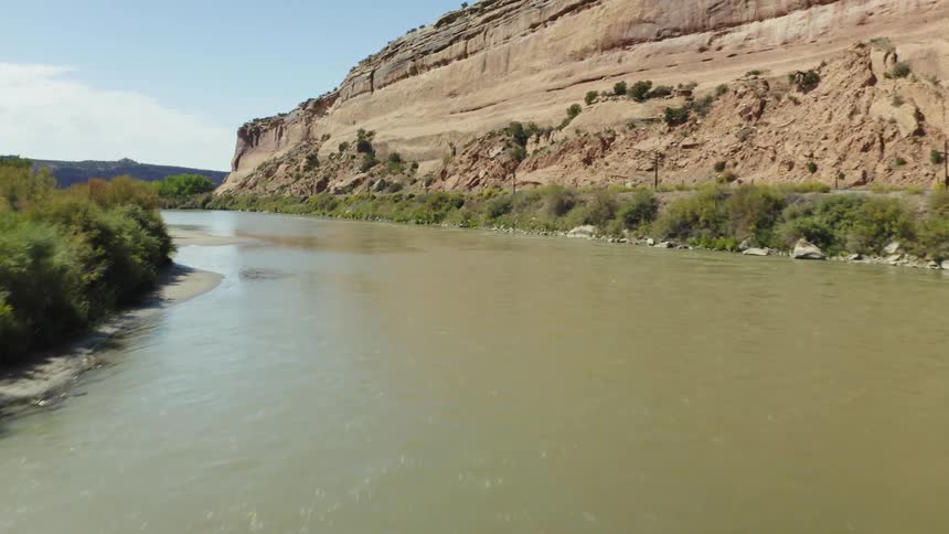 Railroad tracks along a river and mountainside