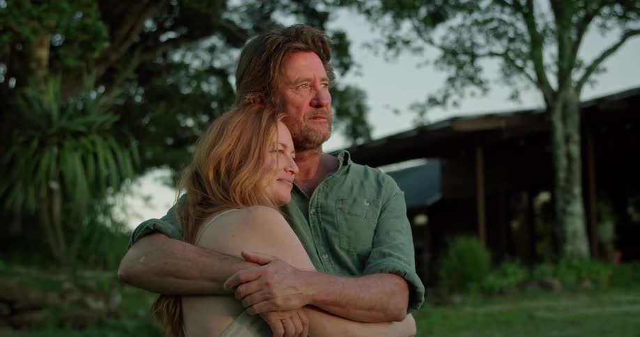Couple hug in the backyard looking at the sunset