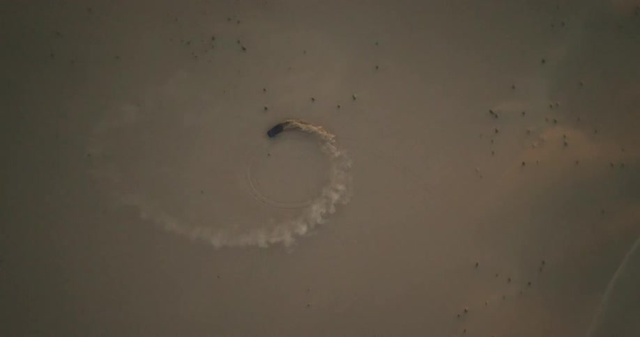 An off-road vehicle is doing donuts in the desert sand
