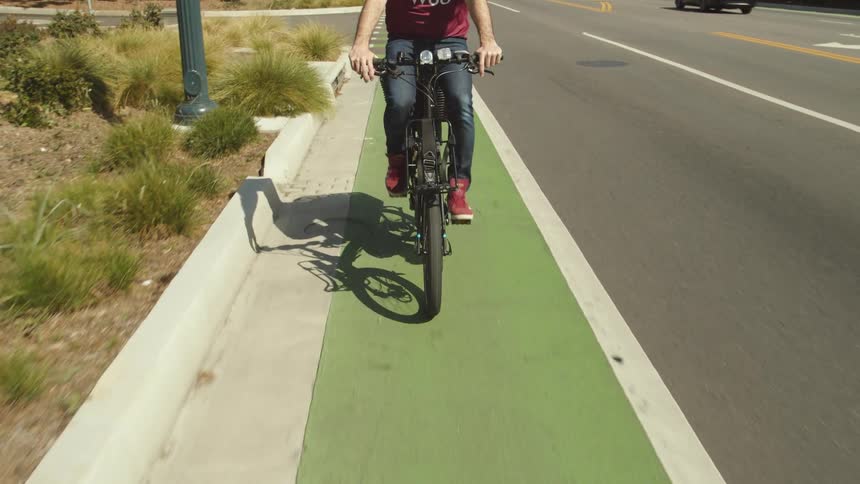 Cyclist driving a bicycle over a bicycle lane on the road