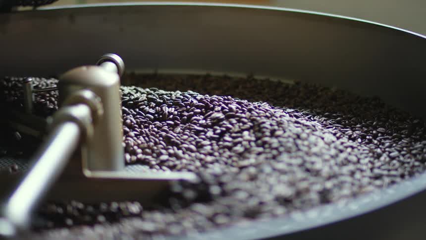 A machine stirs the large amount of beans