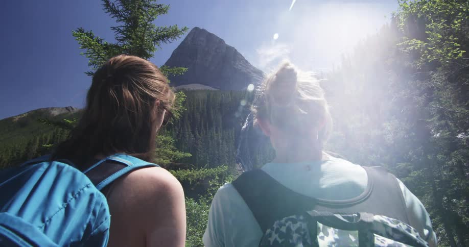 Two girls are hiking near a mountain