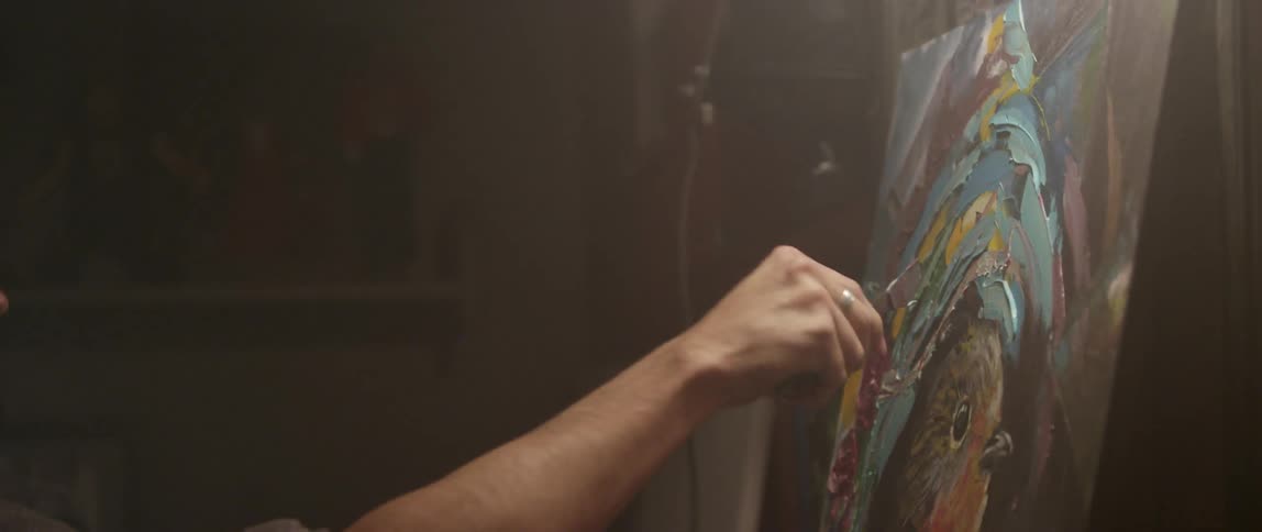A man is painting on a canvas