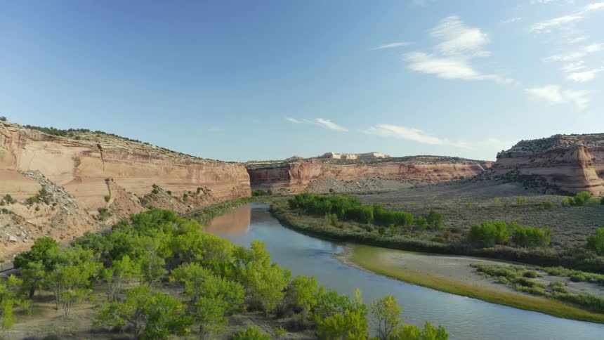 River moves through badlands past plateau topped mountains