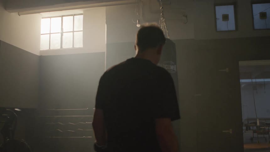 A man is boxing by himself indoors
