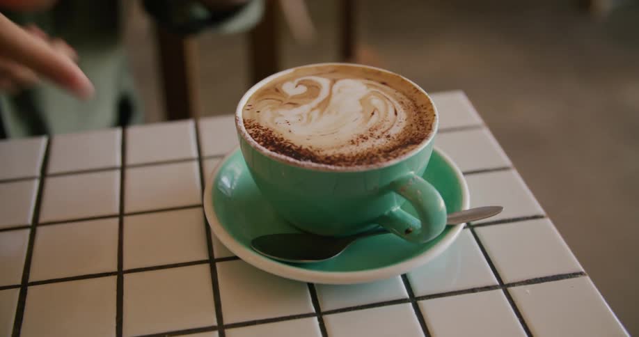 Big mug of latte served on a green cup in a restaurant