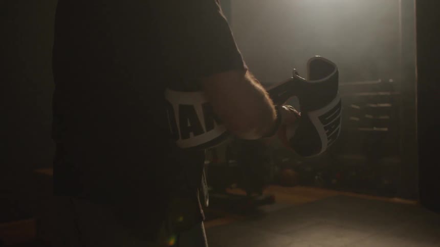 A man is removing his boxing gloves