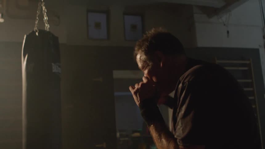 A man is boxing indoors using a punching bag