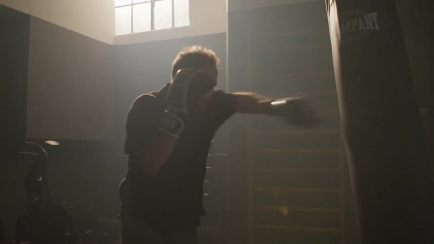 A man is boxing in an empty room indoors