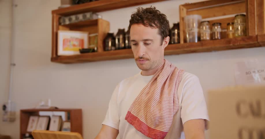 An employee is working at a cafe during the day