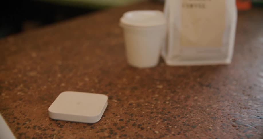 Young man uses his smartphone to pay for cofffee and food to go
