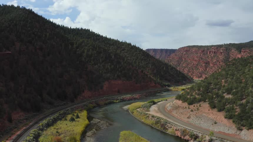 An aerial view of a river in a valley surrounded by a forest