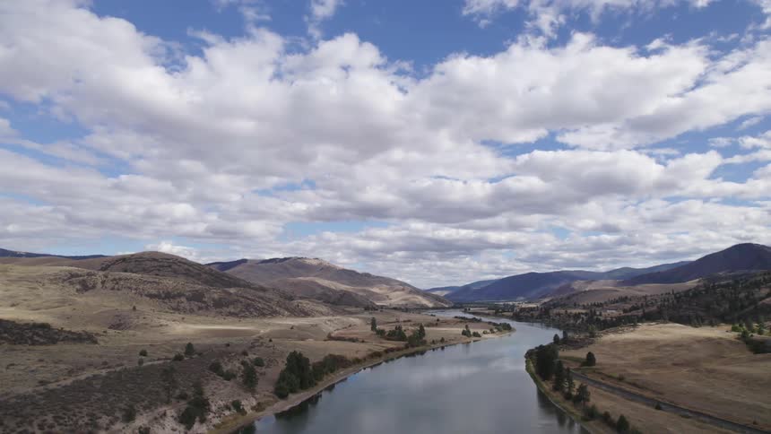 A river through a hilly countryside during the day