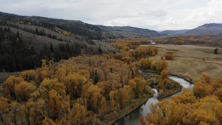 A winding river through a hilly countryside on a cloudy day