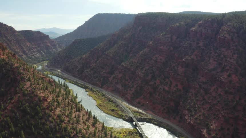 Aerial view of a river between two mountains is displayed