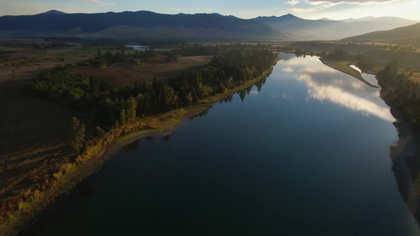 Aerial view of a river with the sun setting in the horizon