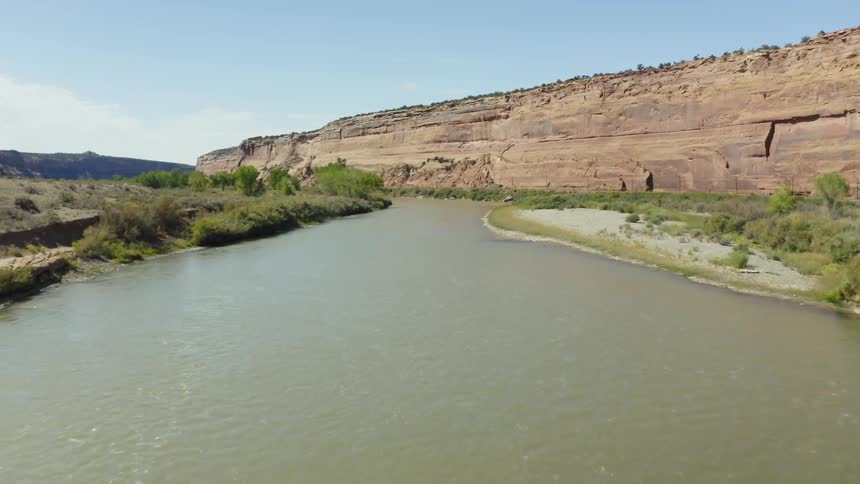 Aerial view of a river flowing near a mesa in the badlands