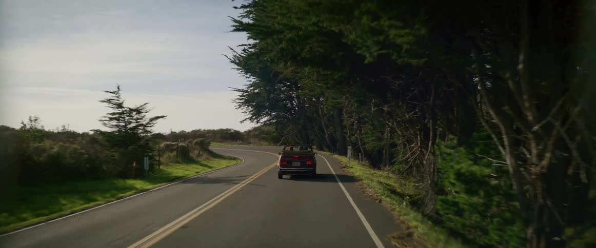 A car is applying the brakes as it approaches a curve in the road