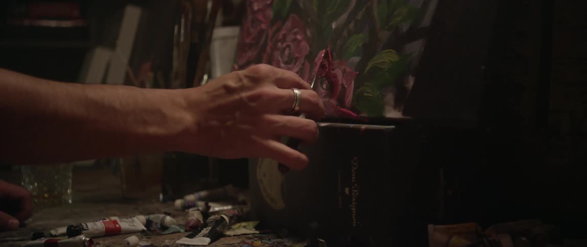 A person is painting flowers on a canvas