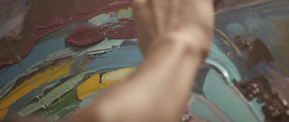 Close up of paint being smeared on a canvas