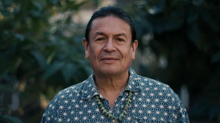 A man is standing outdoors and smiling in spring