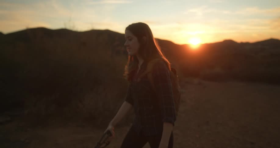 A woman is hiking outdoors at dusk during spring