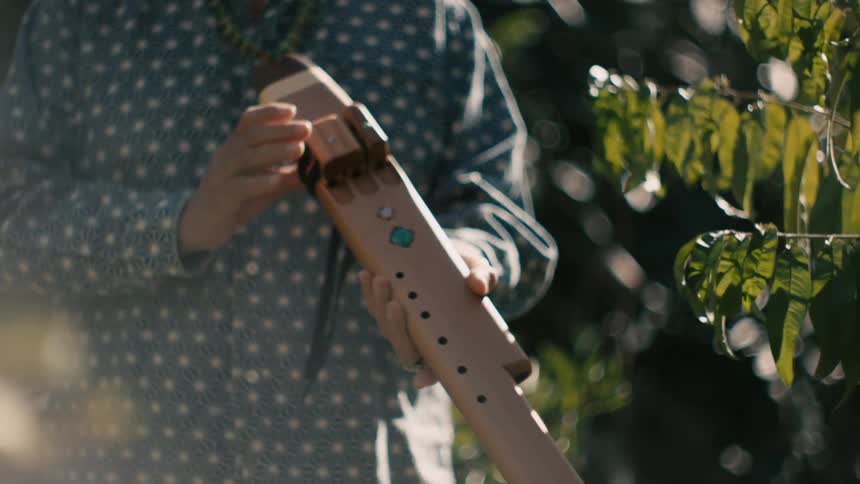 A man is standing outdoors in spring and is holding an object