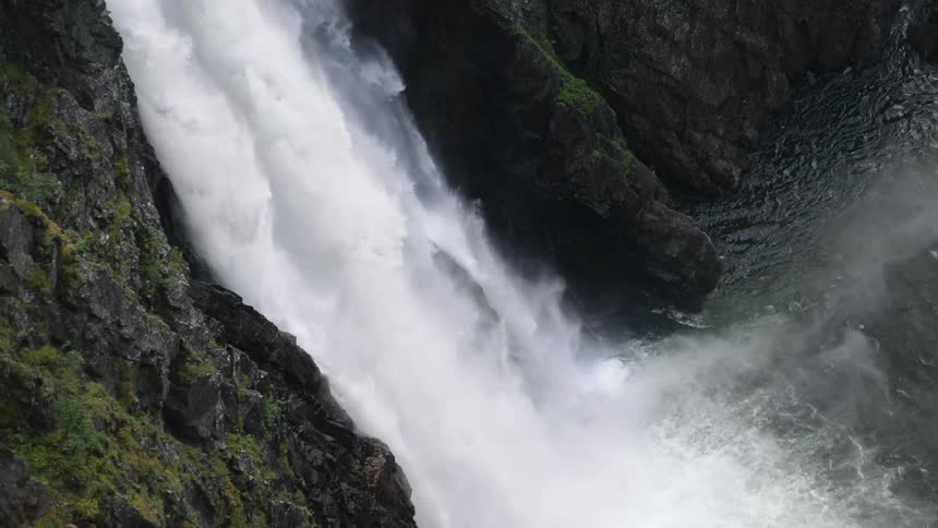The waterfall is giving off mist as the water crashes