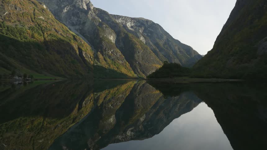 Reflection of the mountains on the calm surface of a lake at morning