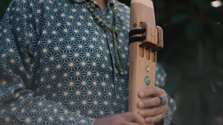 A man holds an instrument outside