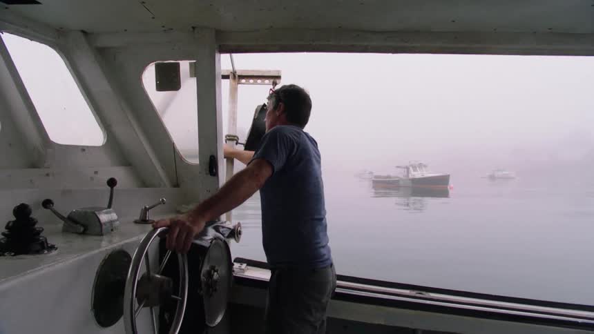 A man is steering the wheel on his boat
