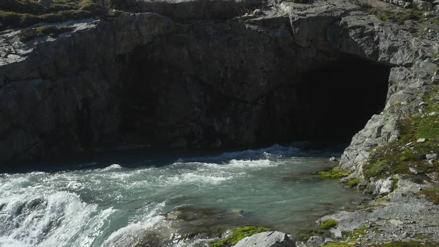A view of water flowing down a river to a waterfall