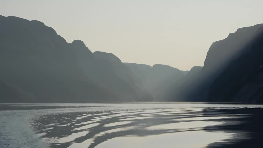 A body of water and mountains on display during the evening