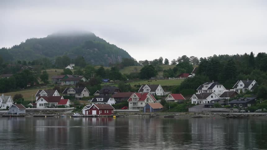 Colorful houses on a waterfront town in the hills near a lake close to a mountain
