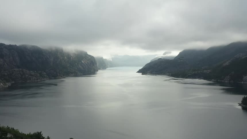 Dense fog and heavy clouds set over a dreary lake
