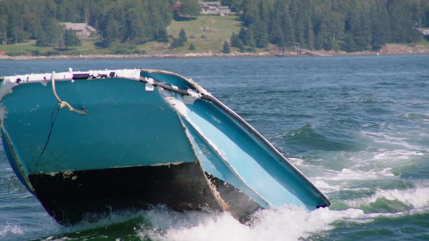 Man driving a small motor boat on a lake near a pine tree forest in the mountains