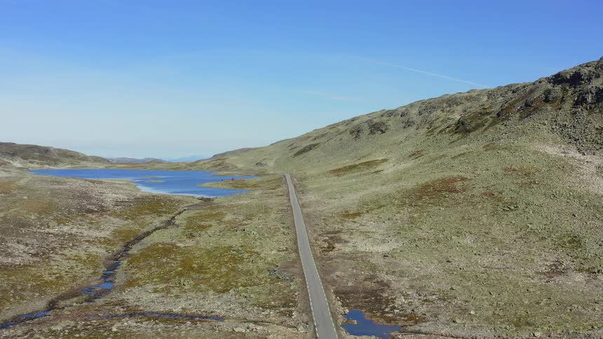 Road along a mountain ridge and a small lake nearby