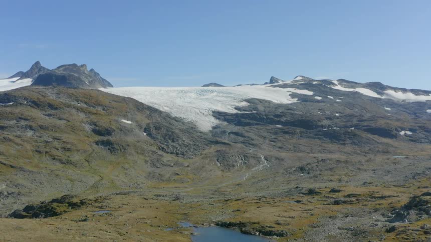 Aerial view of small lakes and pools of water near the snow covered mountain range