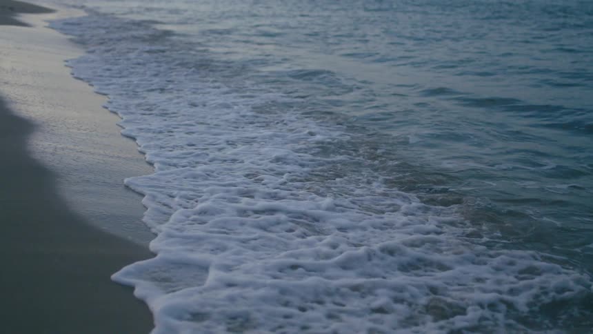 Gentle waves lapping on the shoreline at dusk