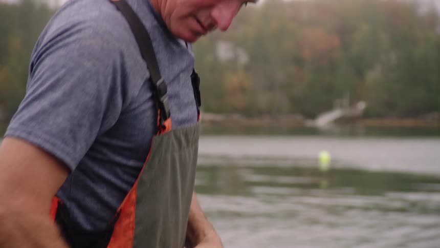 A man throws a bouy in to a lake