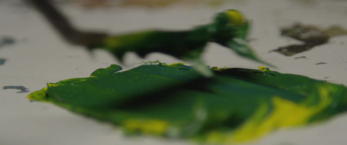 Green and yellow paint is being mixed