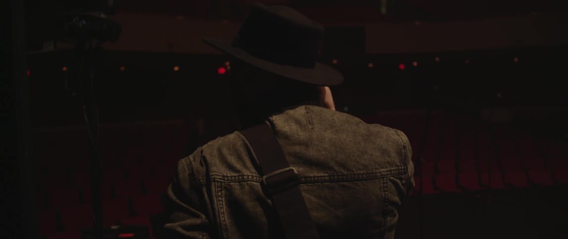 A man in a hat puts on earphones