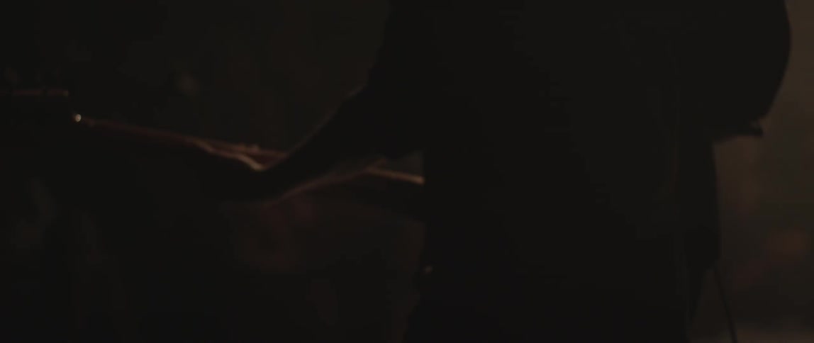 A person plays a guitar in the dark