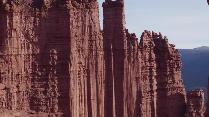 Tall rock formations high in the sky and mountains in the distance