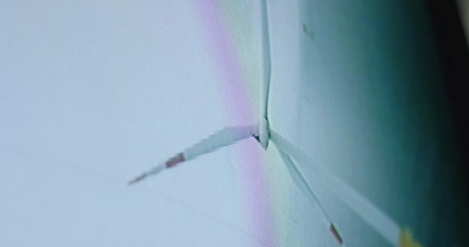 A screen displays a twisting turning spinning wind turbine in the ocean