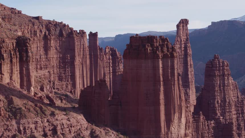 Tall rock formations high in the sky and mountains in the distance