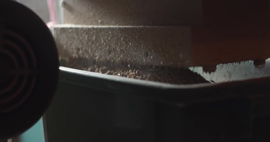 The barley is being filled into the container by a machine