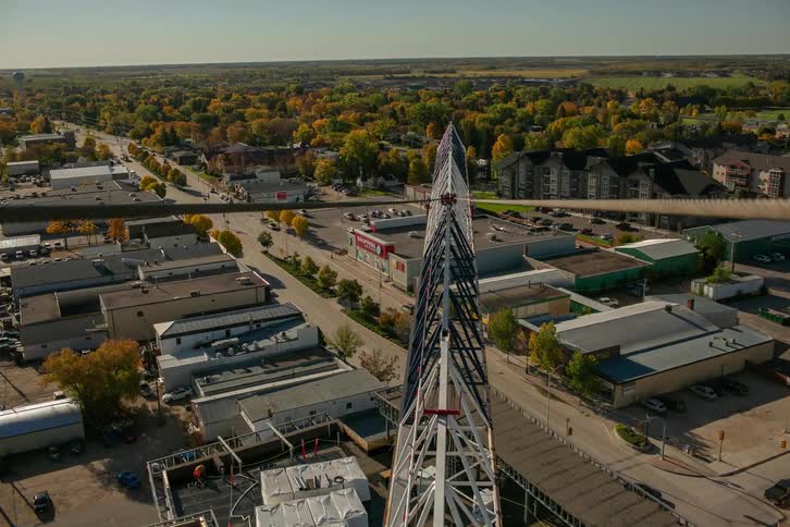 A crane spins on a building over the town