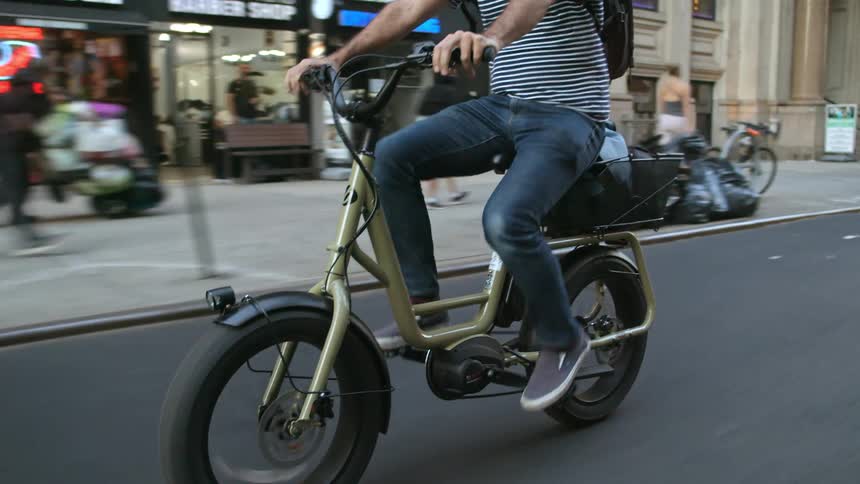 Young man riding a bicycle on the city streets at daytime